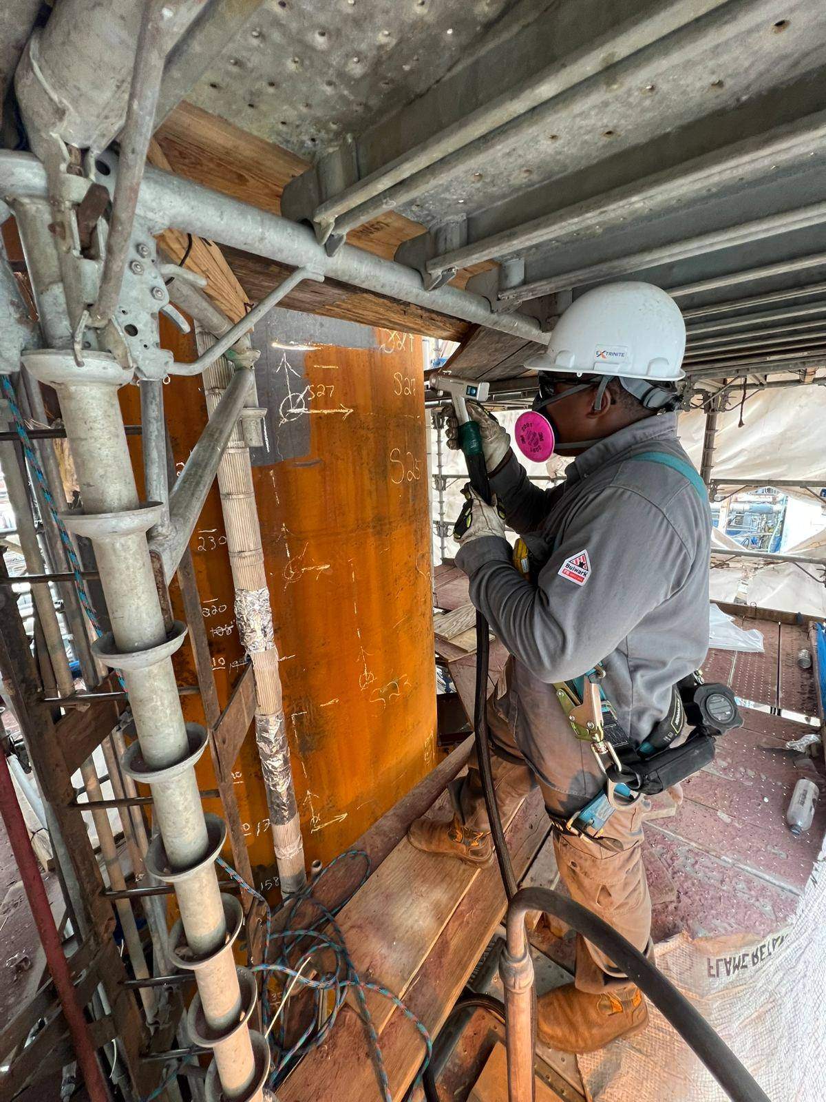Operator running a laser cleaning head on a process column